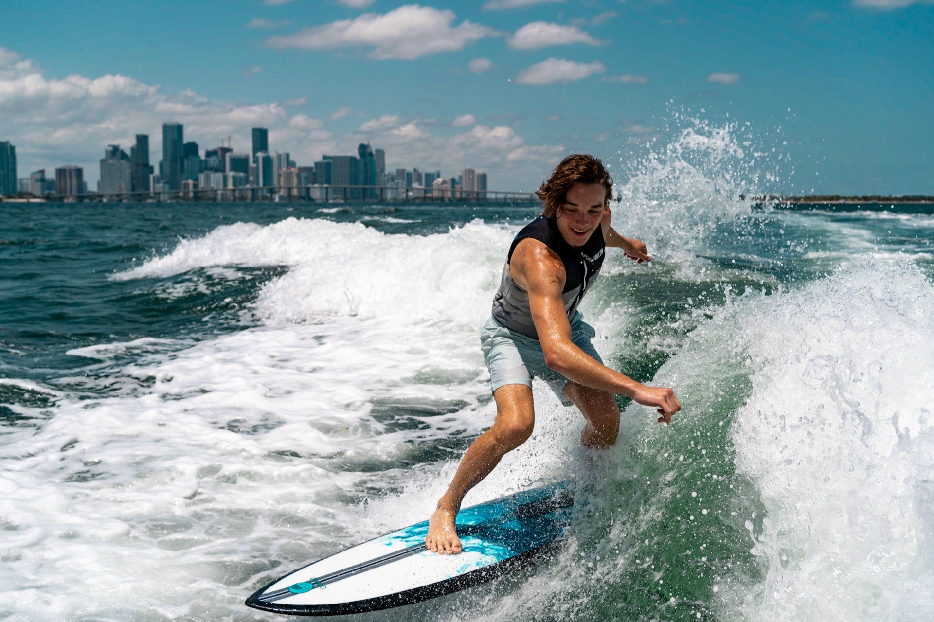 Wakesurfer riding with the Miami skyline behind them